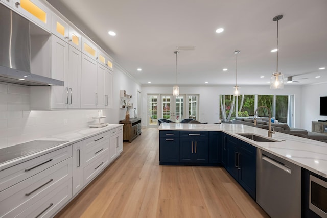 1770 Flagler Manor Cir, West Palm Beach, FL 33411 - kitchen featuring open floor plan, a sink, stainless steel appliances, light wood-style floors, and wall chimney exhaust hood