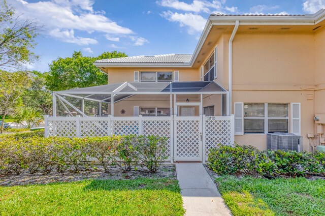 3110 Kingston Ct, West Palm Beach, FL 33409 - view of front of house with stucco siding, central AC, and a lanai