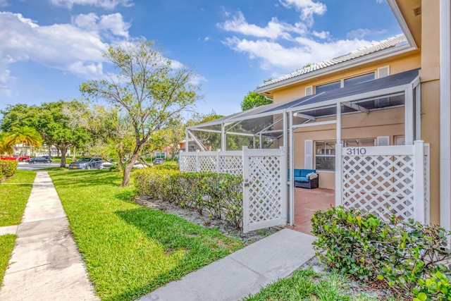 3110 Kingston Ct, West Palm Beach, FL 33409 - view of grassy yard featuring a patio and glass enclosure