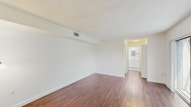 615 6th Ter, Palm Beach Gardens, FL 33418 - unfurnished room featuring dark wood-style flooring, a textured ceiling, and baseboards