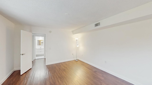615 6th Ter, Palm Beach Gardens, FL 33418 - empty room featuring a textured ceiling, wood finished floors, and baseboards