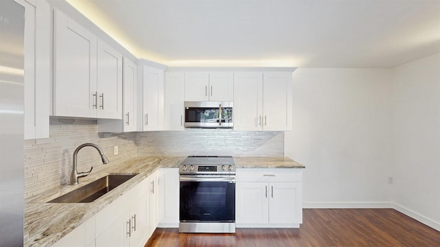615 6th Ter, Palm Beach Gardens, FL 33418 - kitchen with appliances with stainless steel finishes, a sink, decorative backsplash, light stone counters, and dark wood-style floors