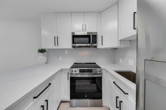 76 Mansfield B 76, Boca Raton, FL 33434 - kitchen featuring stainless steel appliances, light stone countertops, white cabinetry, and backsplash
