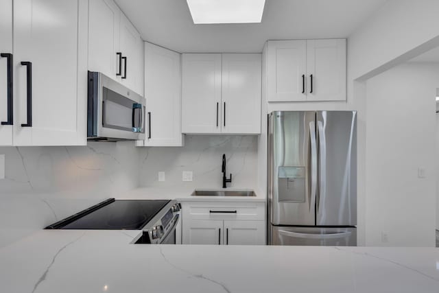 76 Mansfield B 76, Boca Raton, FL 33434 - kitchen with stainless steel appliances, a sink, white cabinets, tasteful backsplash, and light stone counters