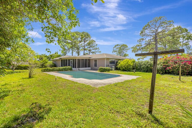 102 SE Crosspoint Dr, Port Saint Lucie, FL 34983 - back of house featuring a sunroom, a yard, and an outdoor pool