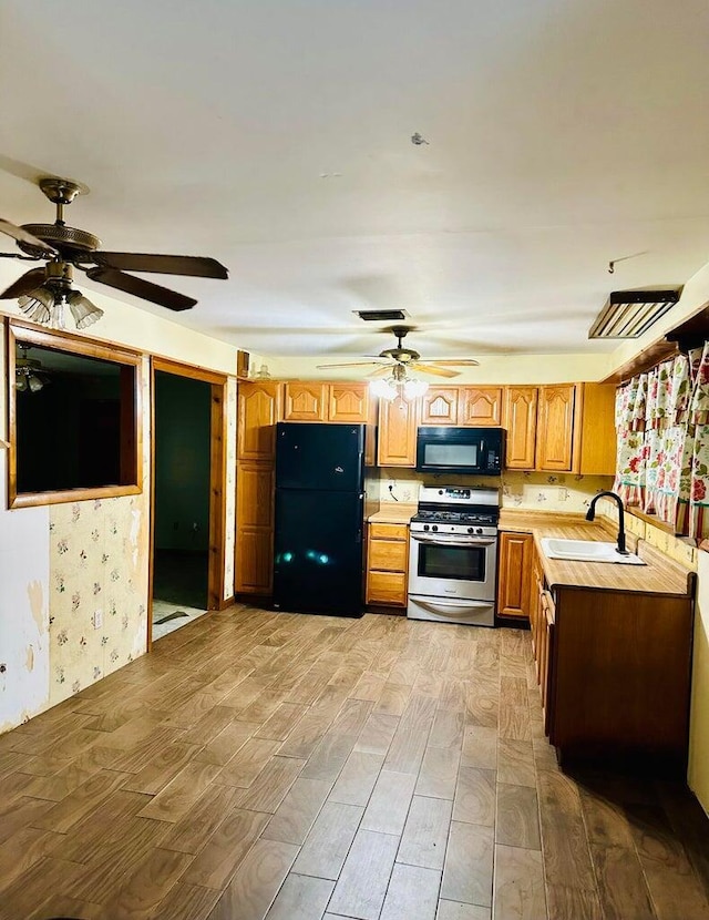 15255 NW 260th St, Okeechobee, FL 34972 - kitchen featuring black appliances, a sink, light wood-style floors, ceiling fan, and light countertops