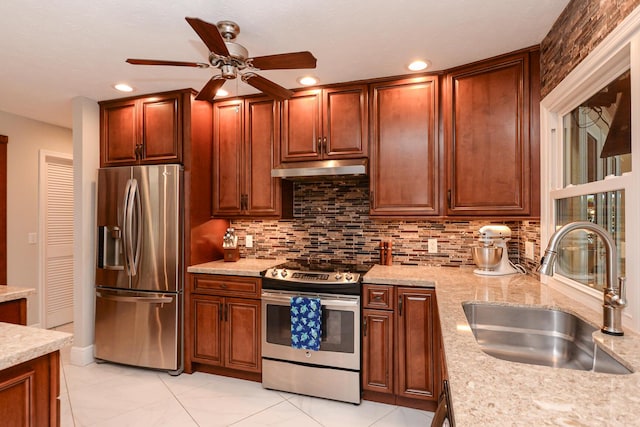 2610 SE Erickson Dr, Port Saint Lucie, FL 34984 - kitchen featuring stainless steel appliances, a sink, under cabinet range hood, ceiling fan, and decorative backsplash