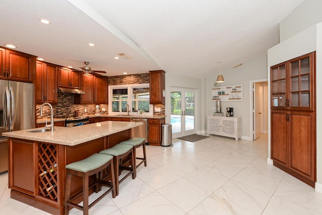 2610 SE Erickson Dr, Port Saint Lucie, FL 34984 - kitchen with stainless steel appliances, a sink, tasteful backsplash, ceiling fan, and light stone counters