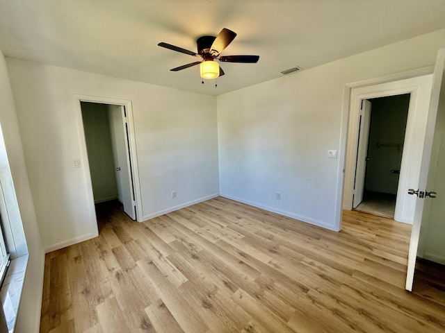 711 NW Riverside Dr, Port Saint Lucie, FL 34983 - unfurnished bedroom featuring light wood-style floors, baseboards, ceiling fan, and a spacious closet