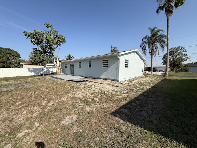 711 NW Riverside Dr, Port Saint Lucie, FL 34983 - rear view of property featuring stucco siding and a patio area