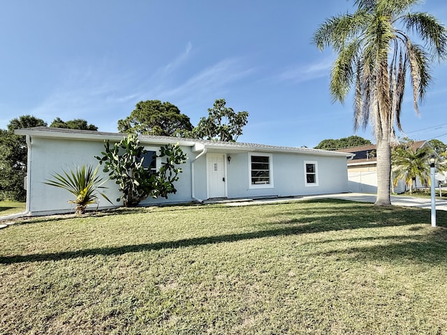 711 NW Riverside Dr, Port Saint Lucie, FL 34983 - ranch-style house featuring stucco siding and a front lawn