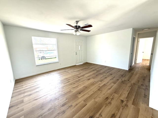 711 NW Riverside Dr, Port Saint Lucie, FL 34983 - empty room featuring a ceiling fan, wood finished floors, and baseboards