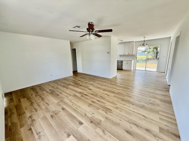 711 NW Riverside Dr, Port Saint Lucie, FL 34983 - unfurnished living room featuring light wood-style floors, a ceiling fan, a chandelier, and baseboards