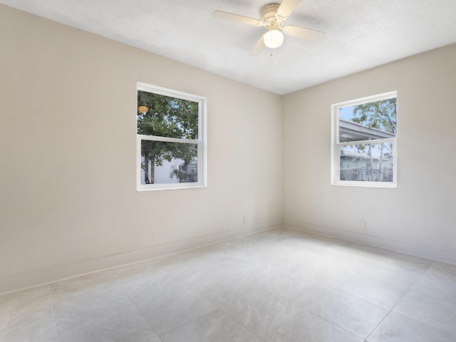 423 N F St, Lake Worth Beach, FL 33460 - empty room with a textured ceiling, ceiling fan, baseboards, and light tile patterned floors