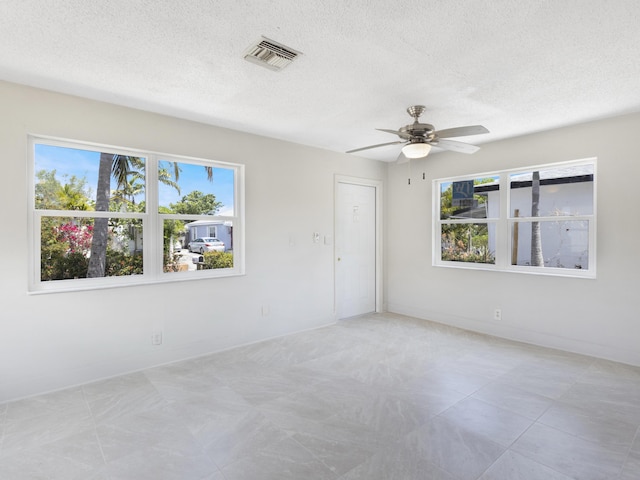 423 N F St, Lake Worth Beach, FL 33460 - unfurnished room with plenty of natural light, a textured ceiling, a ceiling fan, and baseboards