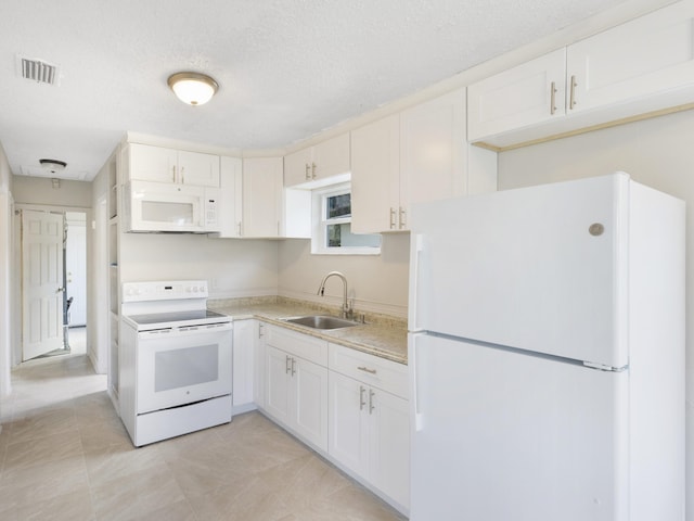 423 N F St, Lake Worth Beach, FL 33460 - kitchen featuring white appliances, a sink, light countertops, white cabinetry, and a textured ceiling