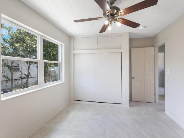 423 N F St, Lake Worth Beach, FL 33460 - unfurnished bedroom with a textured ceiling, baseboards, a closet, and ceiling fan