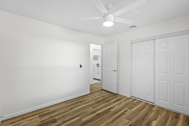 555 Benedictine Ter, Sebastian, FL 32958 - unfurnished bedroom with wood finished floors, baseboards, a closet, and ceiling fan