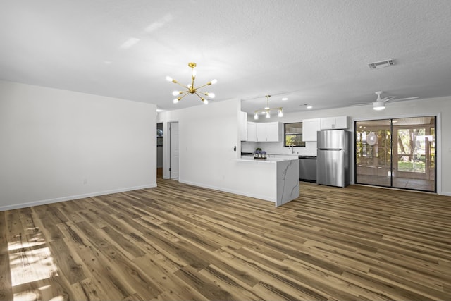 555 Benedictine Ter, Sebastian, FL 32958 - unfurnished living room with a chandelier, dark wood finished floors, baseboards, a sink, and a textured ceiling