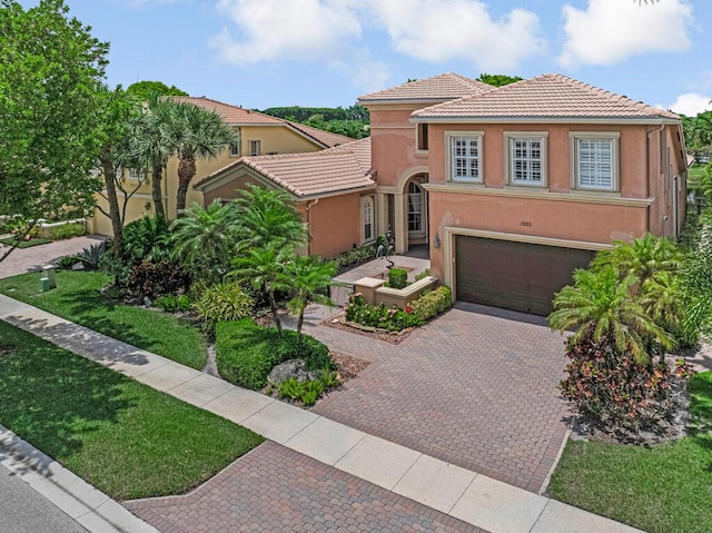 1885 Via Bellezza, Wellington, FL 33411 - mediterranean / spanish house with stucco siding, an attached garage, a tile roof, and driveway