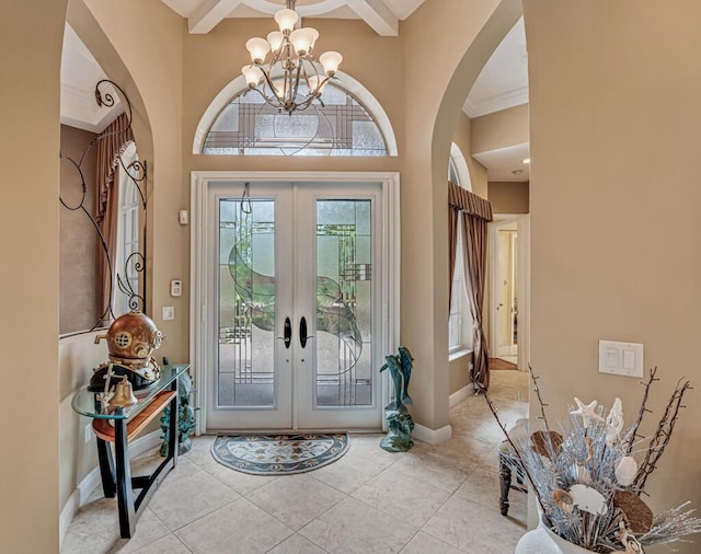 1885 Via Bellezza, Wellington, FL 33411 - foyer featuring french doors, a chandelier, arched walkways, light tile patterned flooring, and beam ceiling