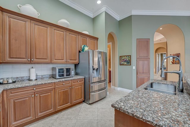 1885 Via Bellezza, Wellington, FL 33411 - kitchen with stainless steel fridge with ice dispenser, a sink, crown molding, stone counters, and brown cabinetry