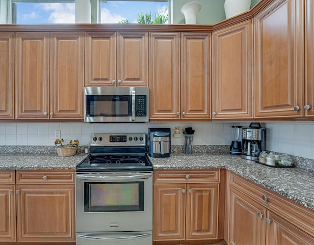 1885 Via Bellezza, Wellington, FL 33411 - kitchen featuring appliances with stainless steel finishes, tasteful backsplash, stone countertops, and healthy amount of natural light