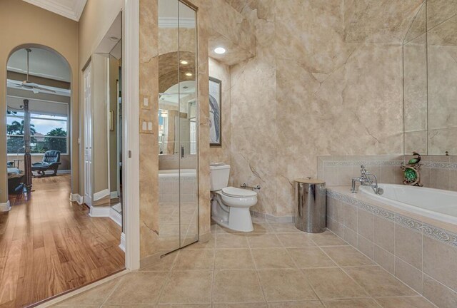 1885 Via Bellezza, Wellington, FL 33411 - bathroom with crown molding, a bath, toilet, ceiling fan, and a shower stall