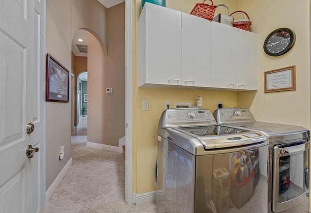 1885 Via Bellezza, Wellington, FL 33411 - laundry room with cabinet space, washing machine and clothes dryer, arched walkways, baseboards, and light tile patterned flooring