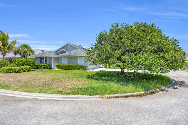 6304 SE Ames Way, Hobe Sound, FL 33455 - single story home with a front lawn and stucco siding