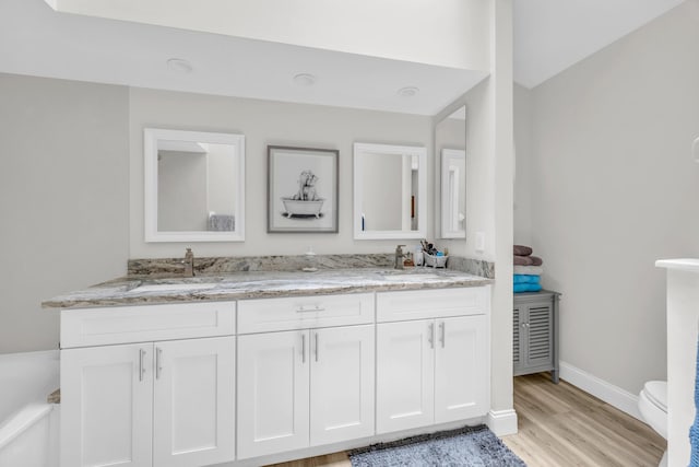 6304 SE Ames Way, Hobe Sound, FL 33455 - full bath featuring double vanity, wood finished floors, toilet, and baseboards
