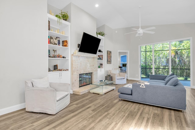 6304 SE Ames Way, Hobe Sound, FL 33455 - living area with baseboards, high vaulted ceiling, wood finished floors, a tiled fireplace, and a ceiling fan