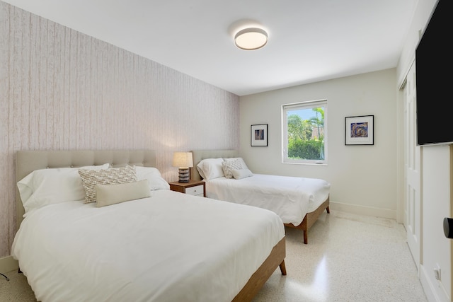 744 Eastwind Dr, North Palm Beach, FL 33408 - bedroom featuring baseboards, speckled floor, and an accent wall
