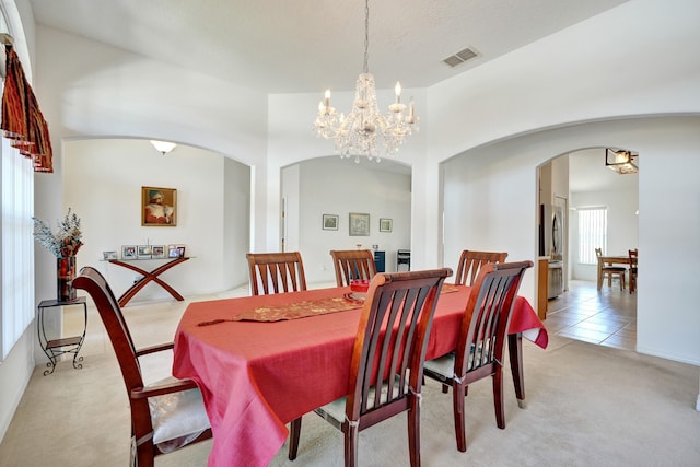 5940 NW Center St, Port Saint Lucie, FL 34986 - dining space with arched walkways, a chandelier, and light carpet