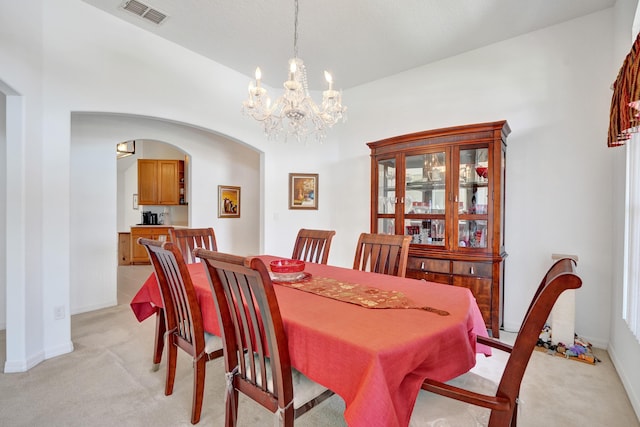 5940 NW Center St, Port Saint Lucie, FL 34986 - dining space with light carpet, arched walkways, a chandelier, and baseboards