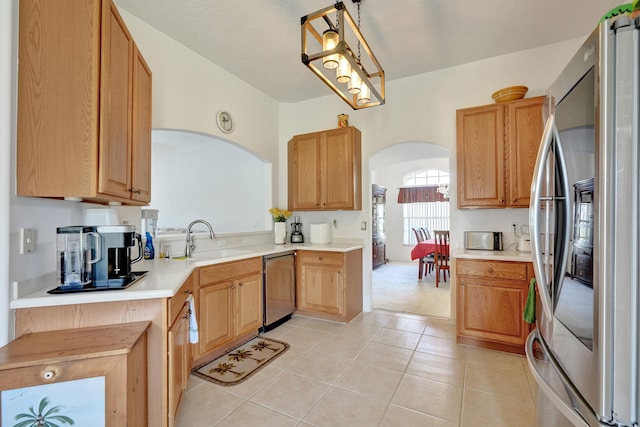 5940 NW Center St, Port Saint Lucie, FL 34986 - kitchen featuring stainless steel appliances, arched walkways, a sink, and light countertops