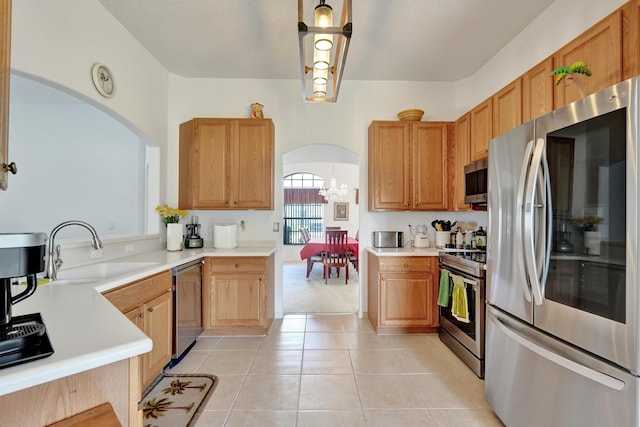 5940 NW Center St, Port Saint Lucie, FL 34986 - kitchen with stainless steel appliances, a sink, arched walkways, a chandelier, and light countertops