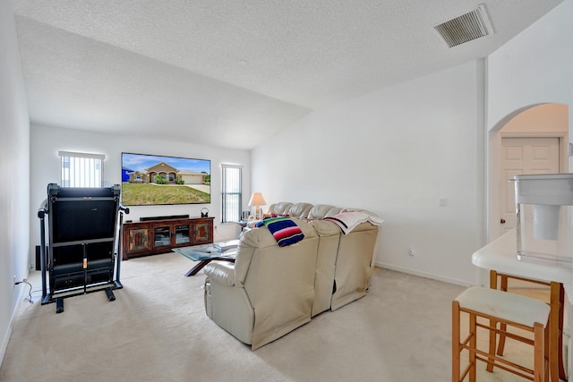 5940 NW Center St, Port Saint Lucie, FL 34986 - living room with light carpet, arched walkways, vaulted ceiling, a textured ceiling, and baseboards