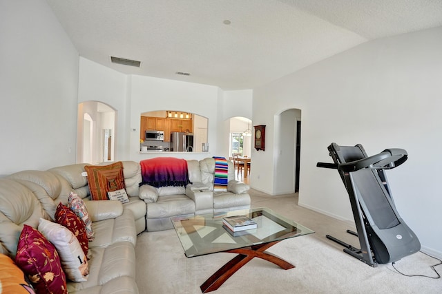 5940 NW Center St, Port Saint Lucie, FL 34986 - living area with arched walkways, light carpet, and vaulted ceiling