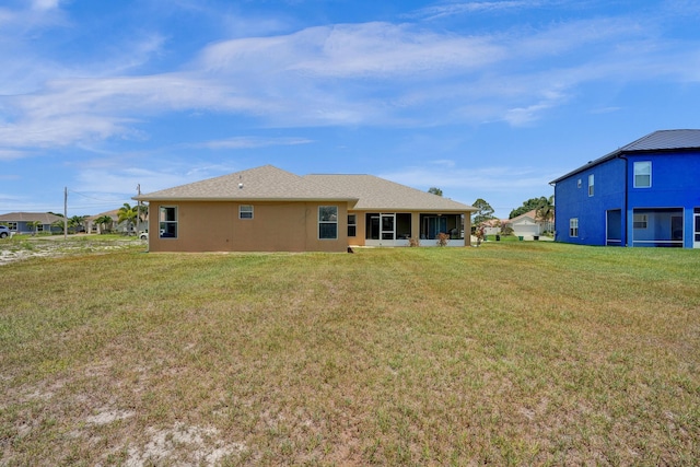 5940 NW Center St, Port Saint Lucie, FL 34986 - rear view of house featuring a yard, stucco siding, and a sunroom