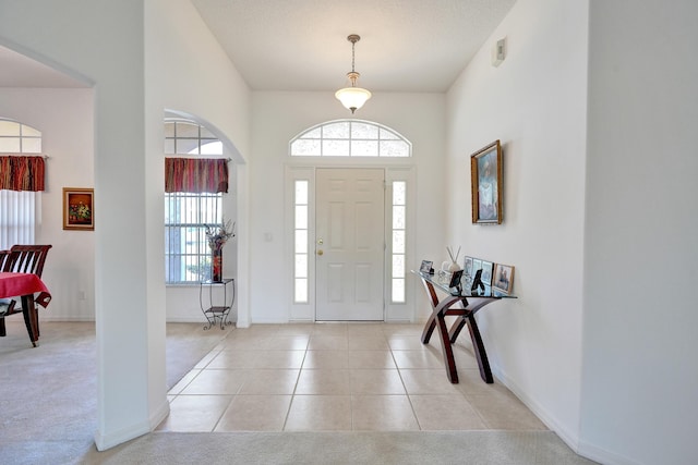 5940 NW Center St, Port Saint Lucie, FL 34986 - foyer entrance with light tile patterned floors, baseboards, and light carpet