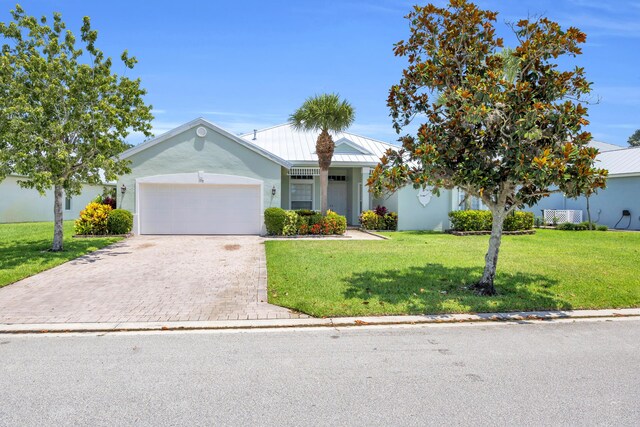 198 Magnolia Lakes Blvd, Port Saint Lucie, FL 34986 - single story home featuring an attached garage, decorative driveway, a front lawn, metal roof, and a standing seam roof