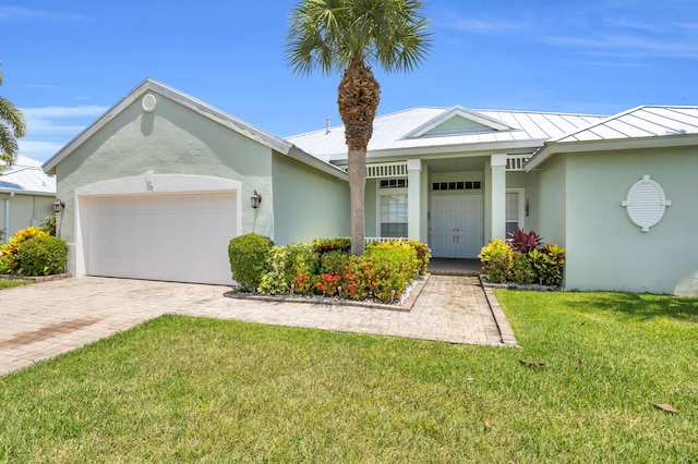198 Magnolia Lakes Blvd, Port Saint Lucie, FL 34986 - ranch-style home featuring stucco siding, a standing seam roof, a front lawn, an attached garage, and driveway
