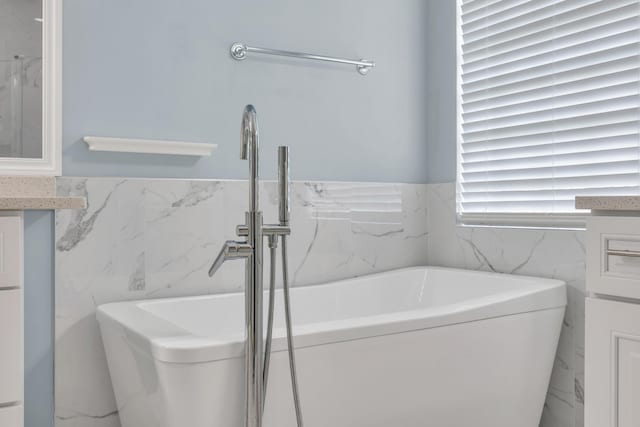 198 Magnolia Lakes Blvd, Port Saint Lucie, FL 34986 - bathroom with a bathtub, tile walls, a sink, wainscoting, and marble finish floors
