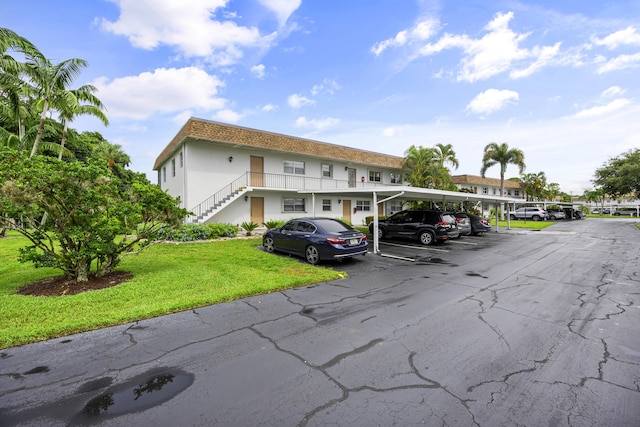 2950 SE Ocean Blvd Unit 9-5, Stuart, FL 34996 - view of building exterior featuring covered and uncovered parking and stairway