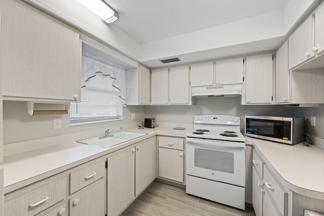 2950 SE Ocean Blvd Unit 9-5, Stuart, FL 34996 - kitchen featuring white range with electric stovetop, stainless steel microwave, under cabinet range hood, a sink, and light countertops