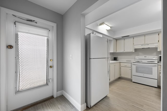 2950 SE Ocean Blvd Unit 9-5, Stuart, FL 34996 - kitchen with white appliances, under cabinet range hood, light countertops, light wood-style floors, and baseboards