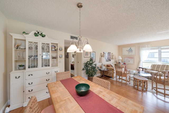 14240 Nesting Way Unit D, Delray Beach, FL 33484 - dining room featuring a textured ceiling, a chandelier, and light wood-type flooring