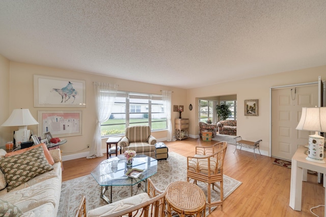 14240 Nesting Way Unit D, Delray Beach, FL 33484 - living room featuring a textured ceiling, light wood finished floors, and baseboards