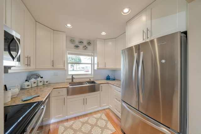 14240 Nesting Way Unit D, Delray Beach, FL 33484 - kitchen featuring stainless steel appliances, a sink, white cabinetry, light wood-style flooring, and recessed lighting